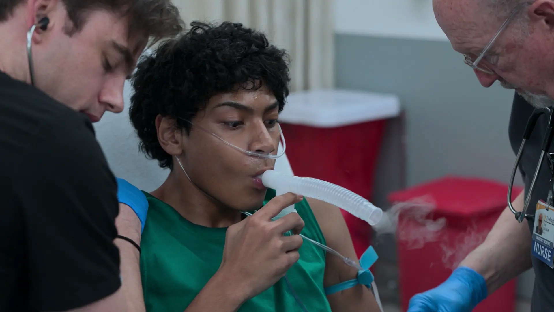 Patient se présentant en détresse respiratoire aiguë, utilisant un embout buccal de nébuliseur portatif tout en présentant un tirage évident des muscles accessoires et des sibilants.