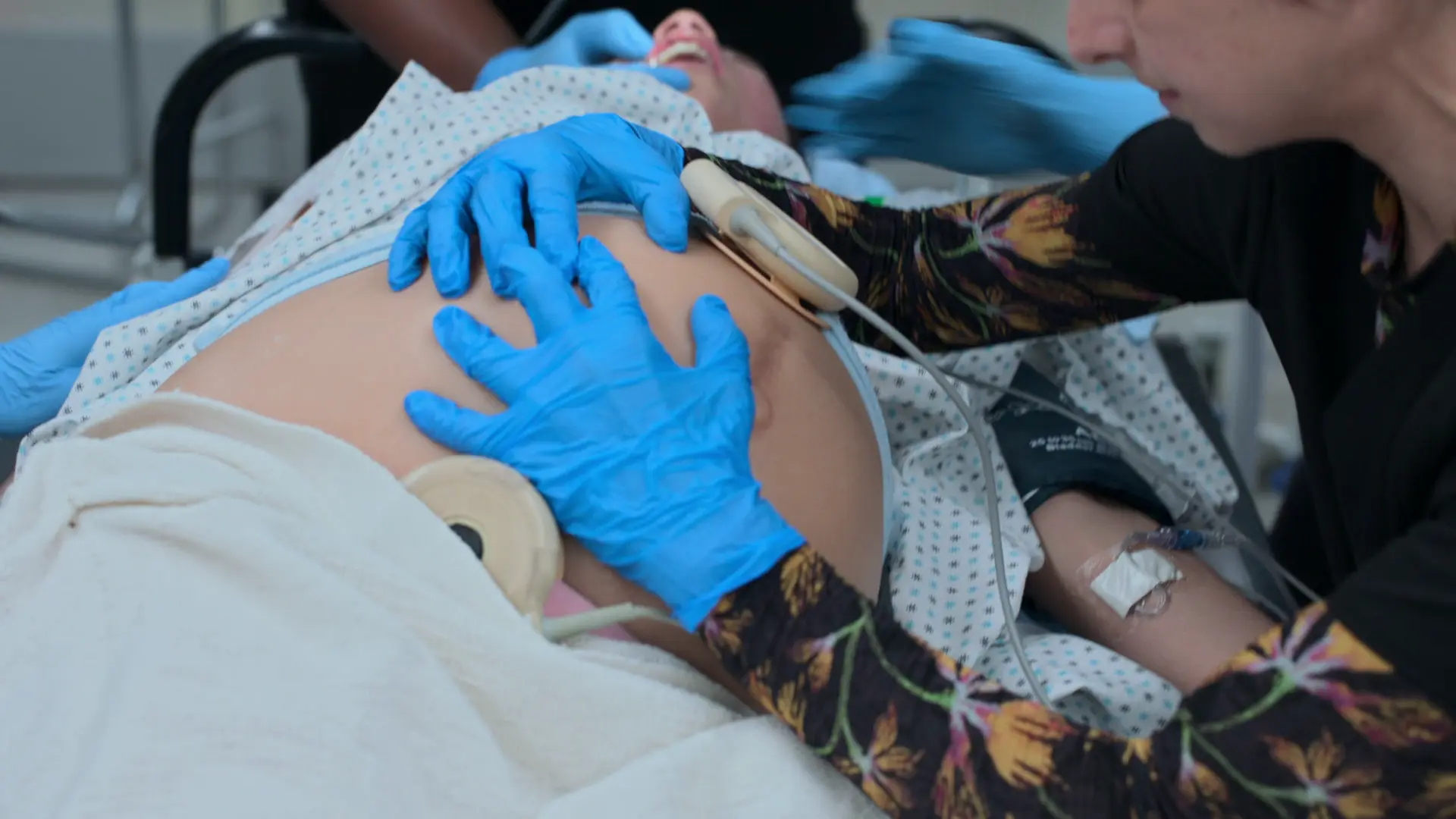 Nazely réalisant un déplacement utérin gauche (DUG) manuel pendant que la patiente est en décubitus dorsal pour l'intubation.